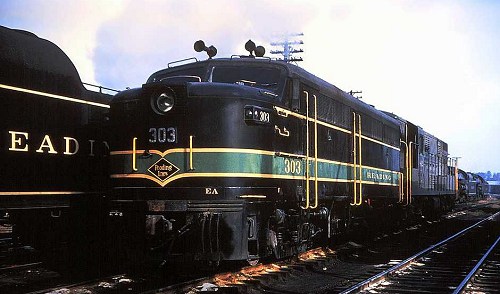 Reading Alco FA-1 #303 shown mated to a Trainmaster, next to a line of stored steam locomotives sometime after 1956.